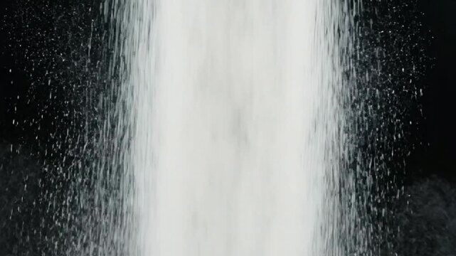 White powder falling against black background, granular texture motion, abstract minimalist particle flow