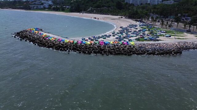 Cinematic aerial drone footage highlighting colorful coastal wave breakers and traditional round basket boats docked along the scenic beach in Mui Ne, Vietnam.