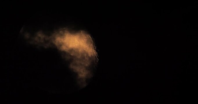 moon behind dark clouds in the night