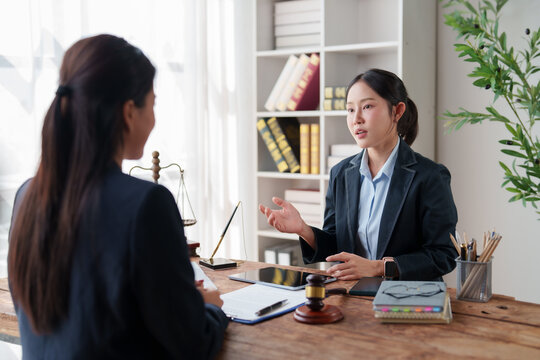 Female lawyer discussing legal advice with client in modern law firm office, offering professional legal consultation and justice services