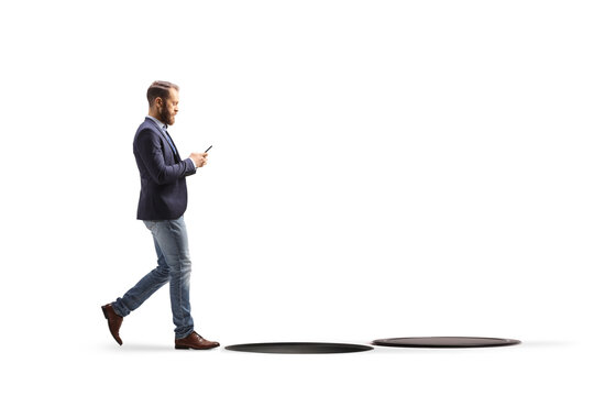 Man walking and typing at his phone about to fall into a hole