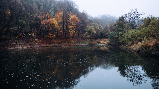 Autumn forest lake reflecting colorful fall trees