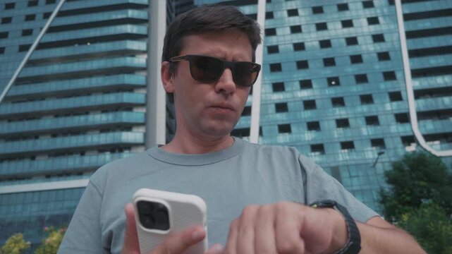 Man reviewing workout progress on smartwatch and smartphone after outdoor exercise in city, checking fitness metrics, activity summary and wearable training data.