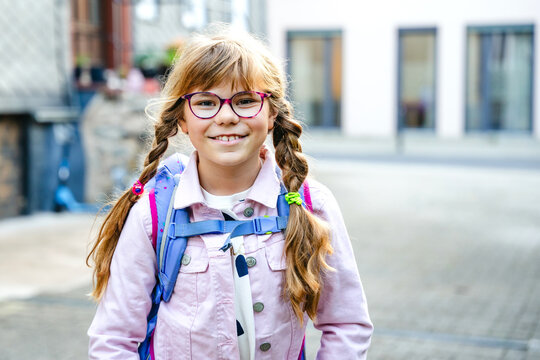 Little Girl on the way to school with a backpack. Happy schoolgirl, back to school concept, walking outdoors with confidence and ready for a new school day