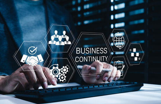 Business continuity and strategy concept. Businessman typing on keyboard with icons representing business continuity, global operations, teamwork, workflow and strategic planning in diverse conditions