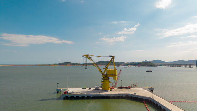 Yellow Crane on a Port Pier by the Water Under Clear Sky