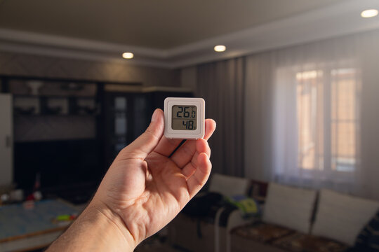 Digital thermostat displaying temperature in home.