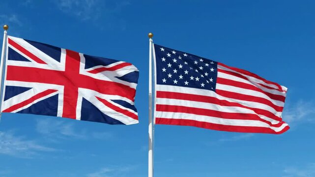 United kingdom and usa flags waving together against a clear blue sky: international diplomacy and partnership concept