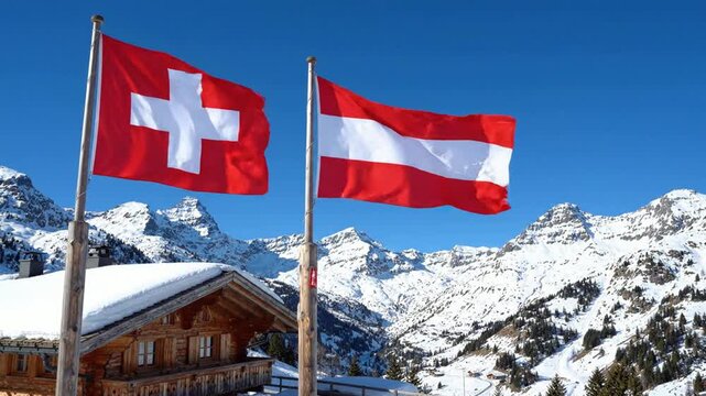 Swiss and austrian flags waving together against snowy alpine mountain landscape and traditional wooden chalet