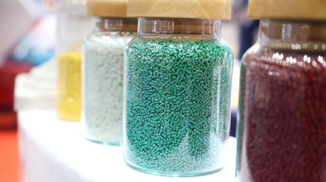 Colorful plastic polymer pellets in glass