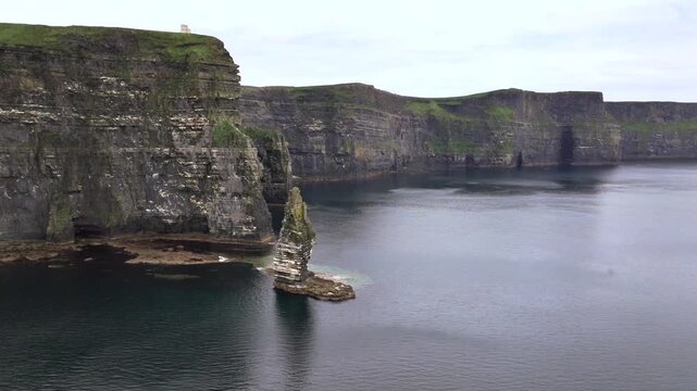 A drone shot of the Cliffs of Moher at cloudy weather, the tallest sea cliffs of the rugged West Clare Coast of Ireland.