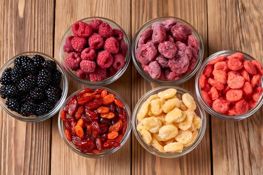 Assortment of healthy freeze dried and fresh berries on wood