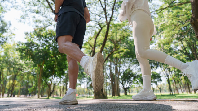 Cropped view of active couple jogging together in park for outdoor workout