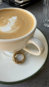 Cup of coffee with golden jewelry, a vintage gold ring. Autumn vibes