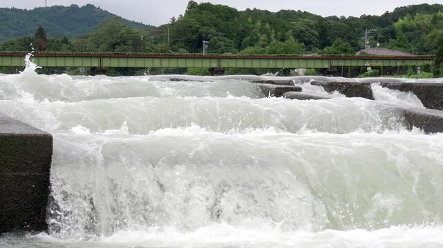 雨上がりに増水した太田川の堰を流れる水
