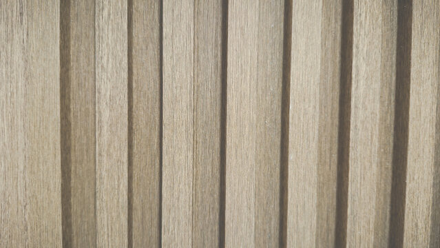 Light brown vertical wood panel texture, modern slatted wall background for interior design. Natural timber ribbed surface pattern.