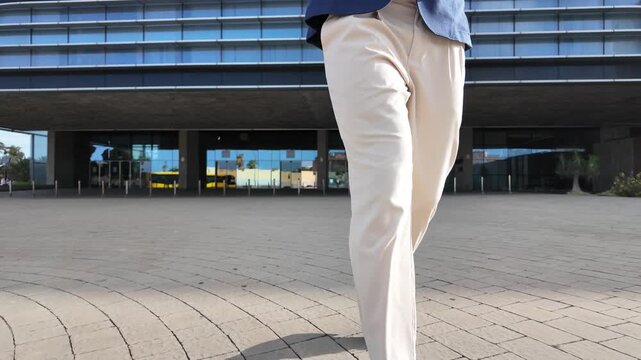 Businessman walking outdoors in an urban area while talking on his smartphone, representing professional communication, mobility and modern business lifestyle.