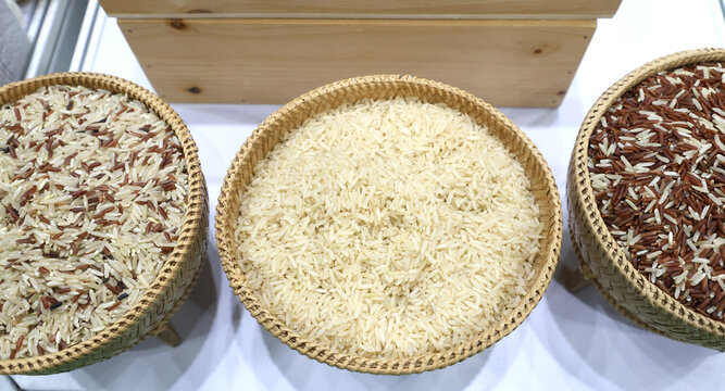 Raw rice grains displayed in woven bamboo baskets