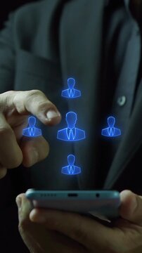Businessman holding smartphone vertical shot touching glowing organization team network hub node. Mobile human resource management, workforce leadership coordination, and collaboration concept.