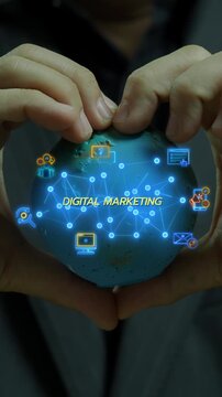 Close-up vertical shot of hands holding world globe model with glowing digital marketing network icons. International online advertising strategy, global brand promotion, and campaign idea concept.