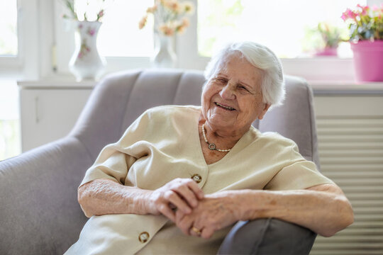 Portrait of an elderly woman sitting in armchair at home
