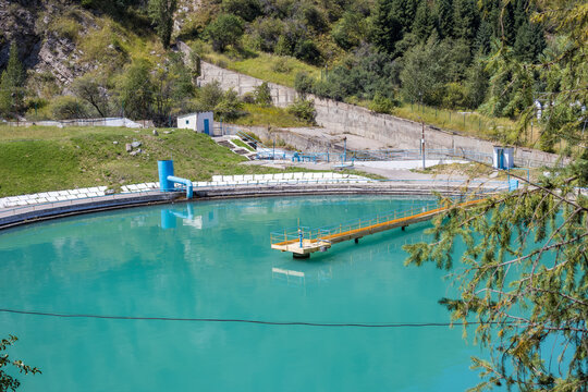 Scenic turquoise reservoir in the Medeu mountain area of Almaty, Kazakhstan, surrounded by green forested slopes. Beautiful mountain scenery representing nature, tourism, water infrastructure and trav
