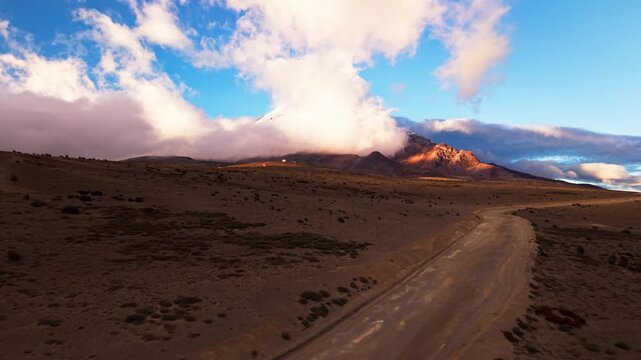Dramatic aerial footage flying over a desolate road leading to the majestic chimborazo volcano