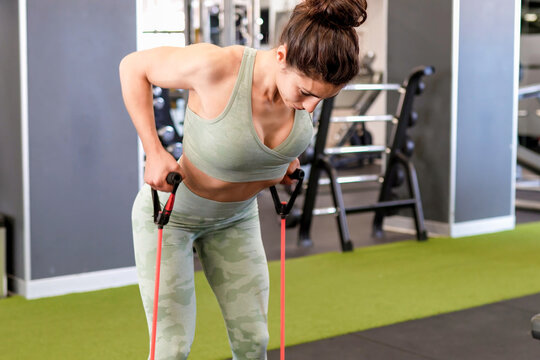 Determined woman passionately executing demanding strength building workouts at gym