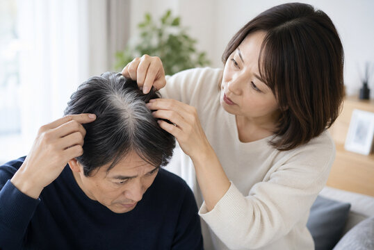 妻に頭頂部の白髪を確認してもらう中年男性