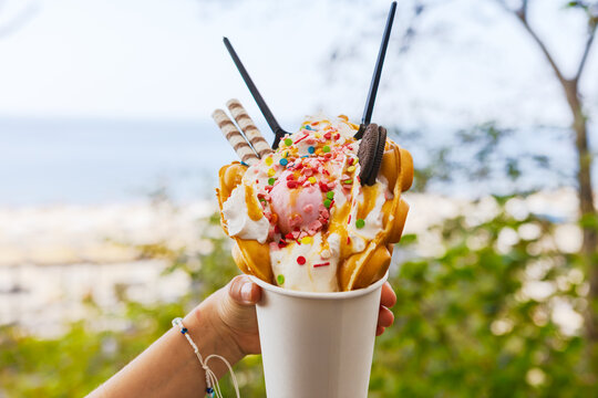 Hand Holding Colorful Bubble Waffle Ice Cream Dessert