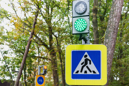 Green Pedestrian Signal With Red Bicycle Signal in Background in Public Park