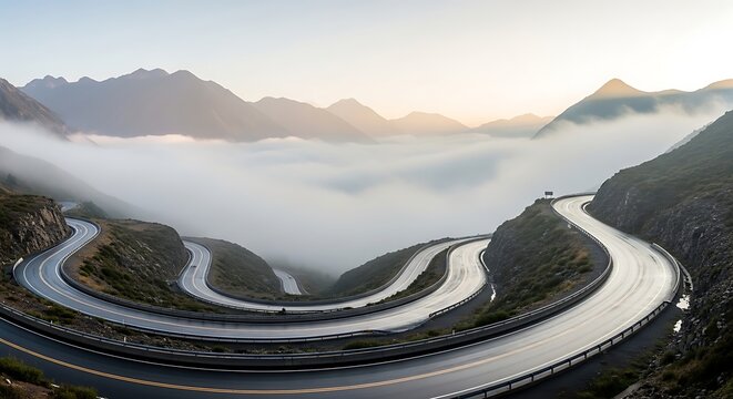 Winding mountain road curves through thick fog during a peaceful sunrise