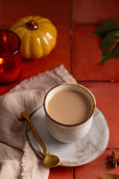Chai tea latte with autumn pumpkin decor, cozy fall drink