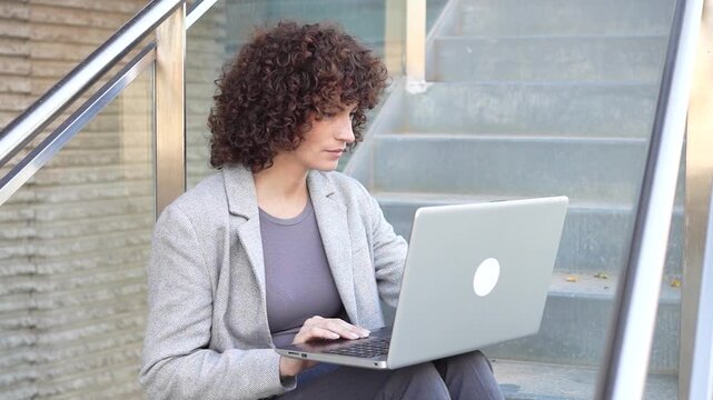 A Focused and Dedicated Professional Working on a Laptop While Sitting Outdoors in Nature