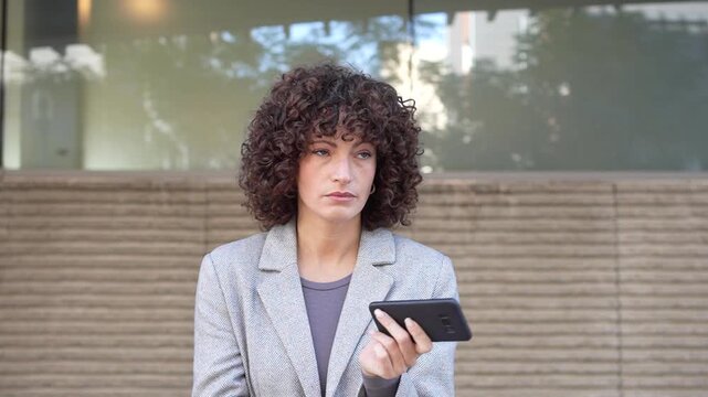 A fashionable individual is engaged with their smartphone, surrounded by an urban setting