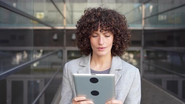 A Professional Woman Engaged with Her Tablet in a Modern and Stylish Workspace Environment