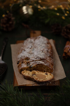 Stollen bread with Christmas lights background, holiday marzipan cake