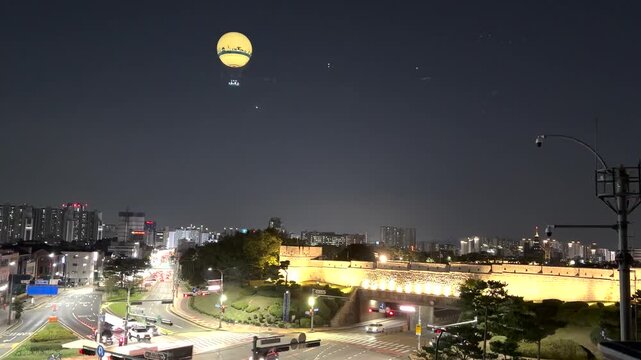 Suwon Hwaseong Fortress at Night with Sightseeing Balloon - Illuminated Historic Wall and Moving City Traffic - Urban Travel Scene in South Korea
