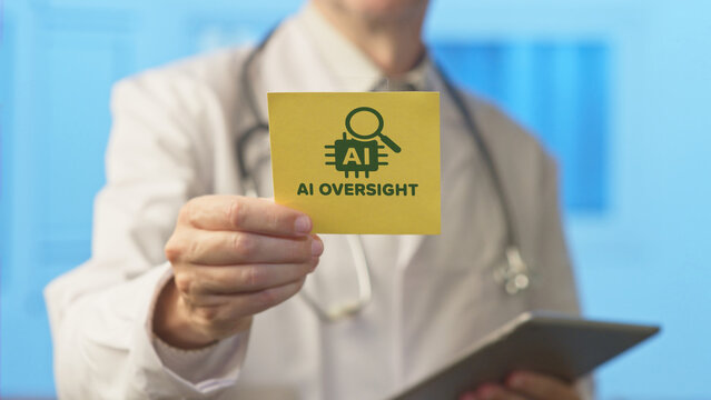 Healthcare professional holding a tablet computer while showing a yellow sticky note with an ai oversight icon, symbolizing the importance of monitoring artificial intelligence in modern medicine