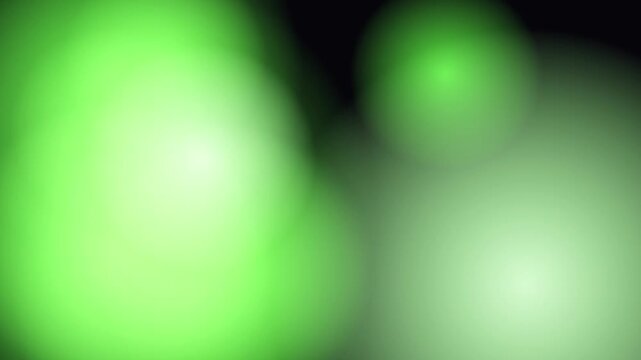 Abstract background of soft green blurred circles and organic shapes shifting on a black backdrop. Minimalist out-of-focus bokeh lights featuring lime and mint gradients for cinematic overlays.