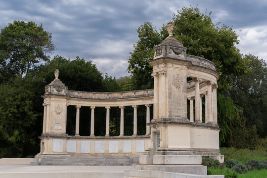 Semicircular War Memorial Monument with Stone Colonnade under Cloudy Sky in Montpellier