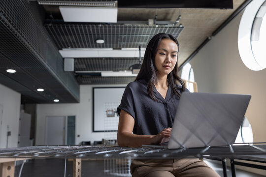 Focused woman working on her laptop in a modern office