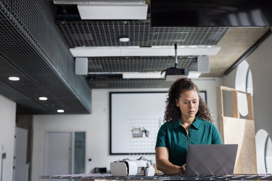 Young woman engaged in tech tasks at her workstation