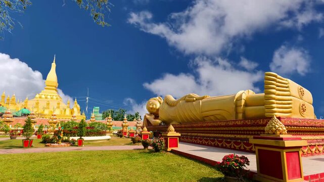 Reclining Buddha statue outside temple next to the iconic Pha That Luang stupa in Vientiane, Laos.Laos Golden Reclining Buddha adjacent to Pha That Luang in Vientiane, Laos