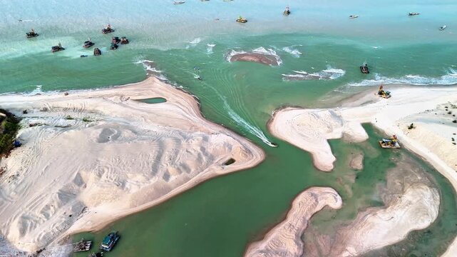 coastal sand mining operation with dredging vessels transforming shoreline landscape and revealing industrial activity in marine areas