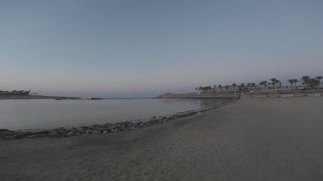 sunset over the Red Sea at Coraya Beach near Marsa Alam, Egypt, with warm golden and orange light reflecting across the calm water.
