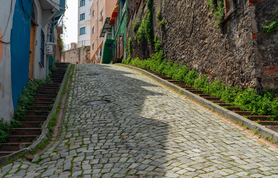 Steep cobblestone street with stone stairs and colorful old buildings in historic Istanbul city Turkey