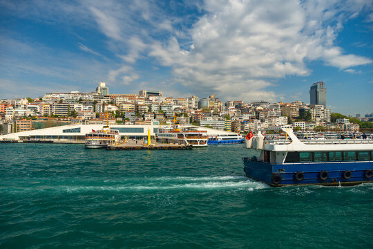 Panoramic view of Istanbul cityscape with ferry boats cruising on the Bosphorus sea near Galata and Emin&ouml;n&uuml; waterfront under a blue cloudy sky