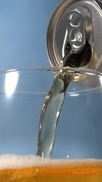 Beer pouring from aluminum can into glass in super slow motion