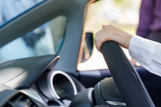 Close up of driver hand holding steering wheel inside car